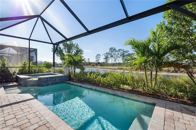 view of swimming pool featuring a patio area, a pool with connected hot tub, a water view, and a lanai