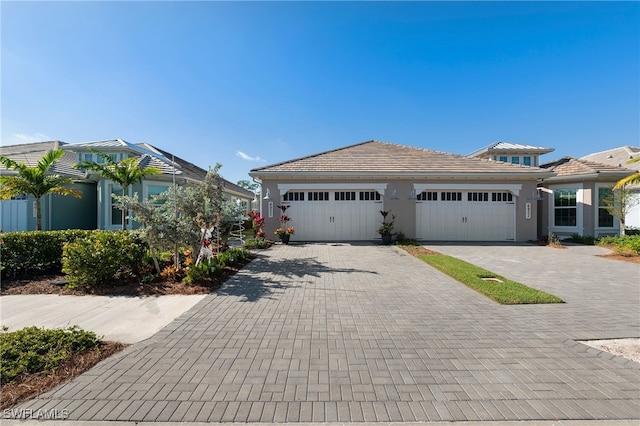 view of front of property with a garage, decorative driveway, and stucco siding