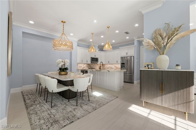 dining area featuring sink and crown molding