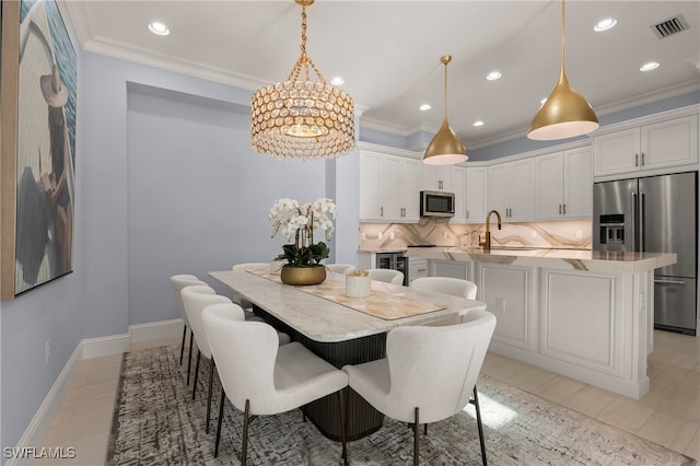 dining room featuring crown molding, sink, and a notable chandelier