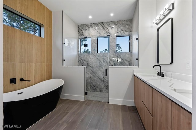 bathroom featuring plus walk in shower, wood-type flooring, vanity, and a wealth of natural light