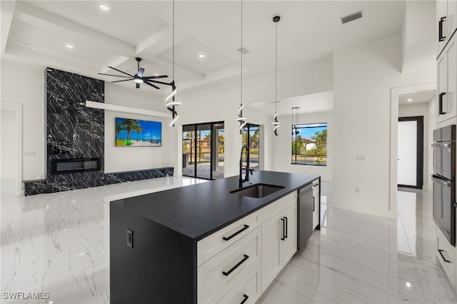 kitchen featuring pendant lighting, a kitchen island with sink, coffered ceiling, sink, and white cabinetry