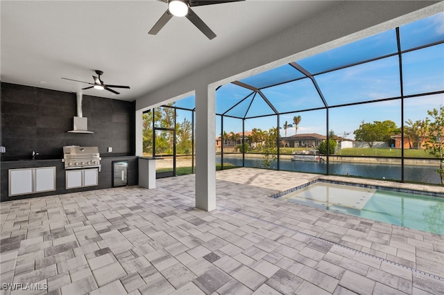 view of patio with ceiling fan, exterior kitchen, a lanai, grilling area, and a water view