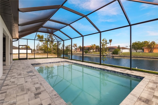 view of swimming pool with a lanai, a patio area, and a water view