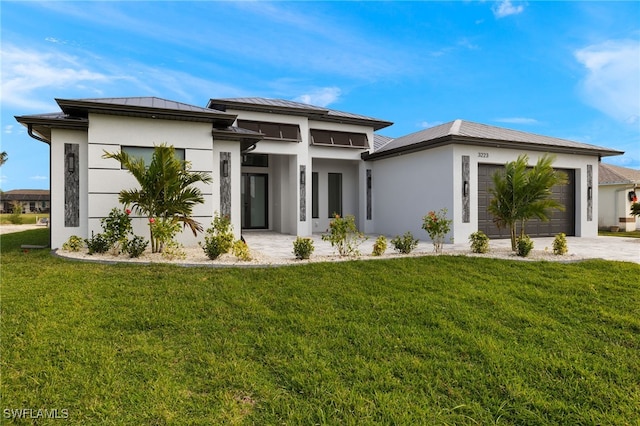 prairie-style house with a front lawn, concrete driveway, stucco siding, a garage, and a standing seam roof