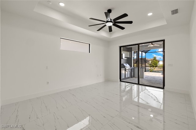 unfurnished room with a tray ceiling and ceiling fan