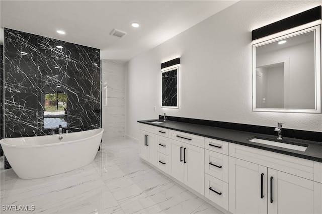 bathroom with a tub to relax in, vanity, and tile walls