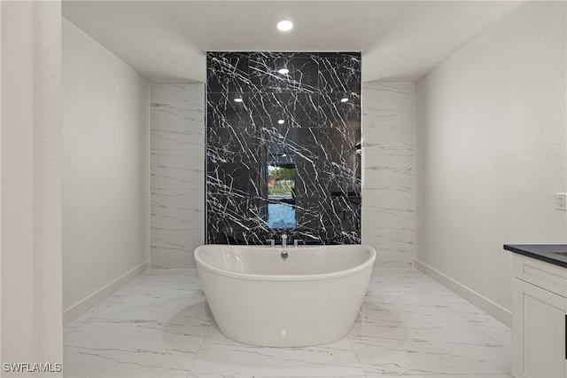 bathroom with vanity, a tub to relax in, and tile walls