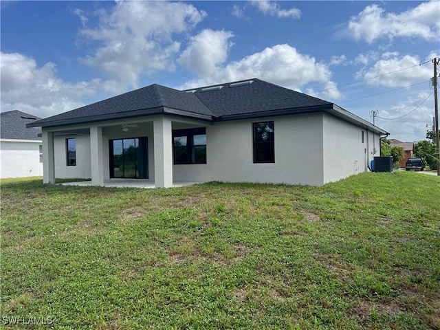 rear view of property with a yard and cooling unit