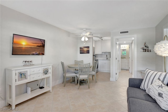 tiled dining room featuring ceiling fan and sink