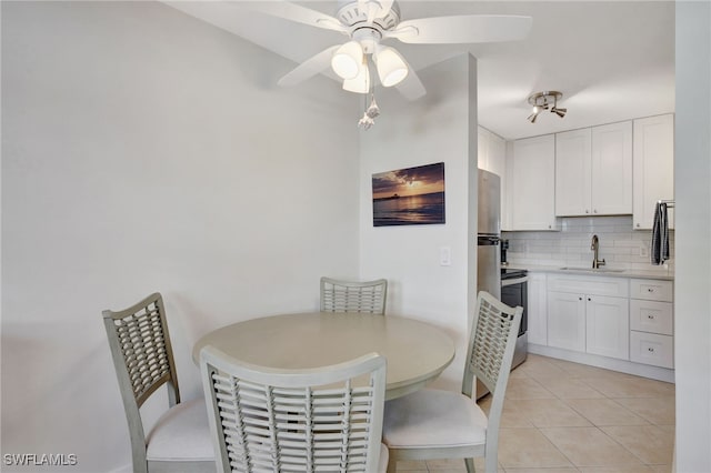 dining room featuring ceiling fan, sink, and light tile patterned flooring