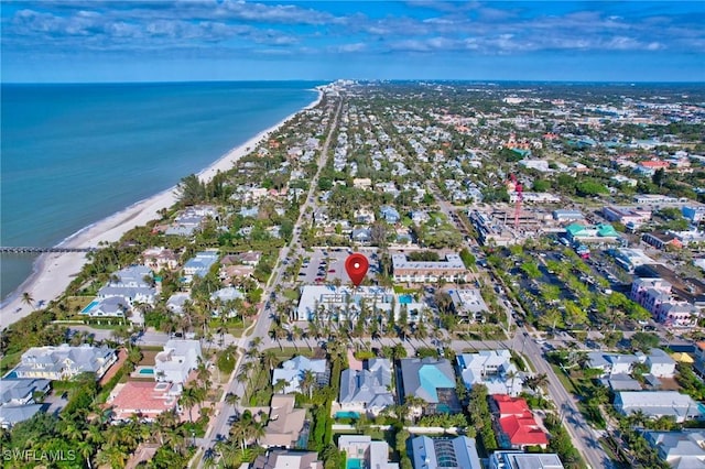 drone / aerial view featuring a water view and a view of the beach