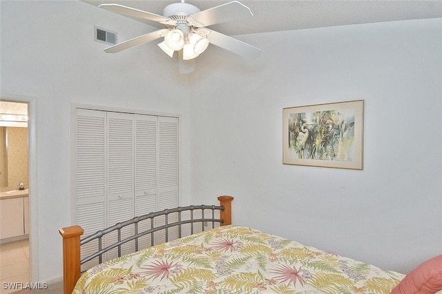 bedroom with ceiling fan, sink, ensuite bathroom, and a closet