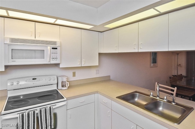 kitchen with sink, white appliances, and white cabinets