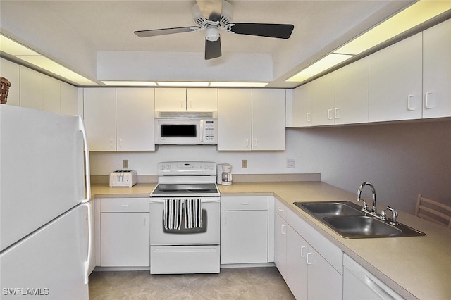 kitchen with sink, white appliances, and white cabinetry