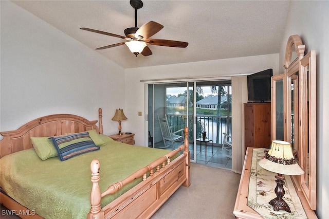 carpeted bedroom featuring a textured ceiling, access to exterior, vaulted ceiling, and ceiling fan