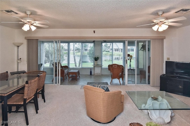 living room with ceiling fan and a textured ceiling