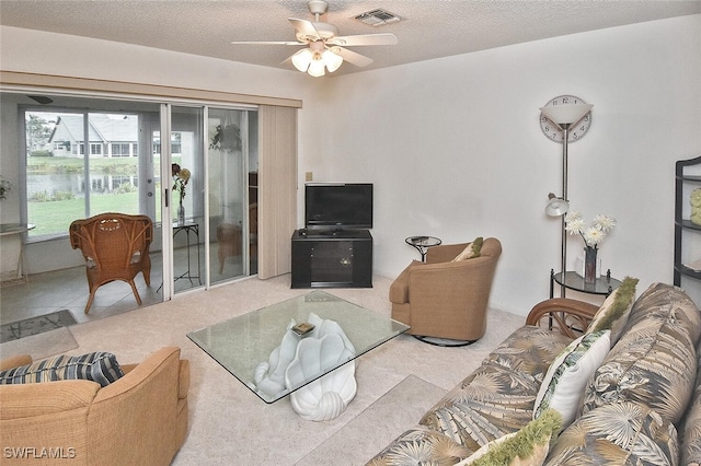 living room featuring ceiling fan and a textured ceiling