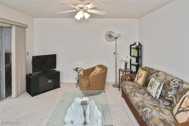 living room with ceiling fan, a textured ceiling, and light carpet