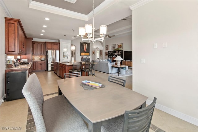 tiled dining room featuring ceiling fan with notable chandelier, sink, a raised ceiling, and crown molding