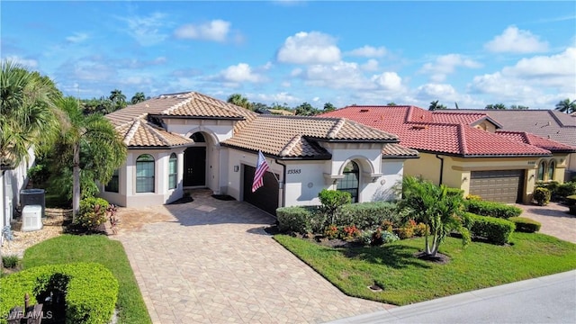 mediterranean / spanish home with a front yard and a garage