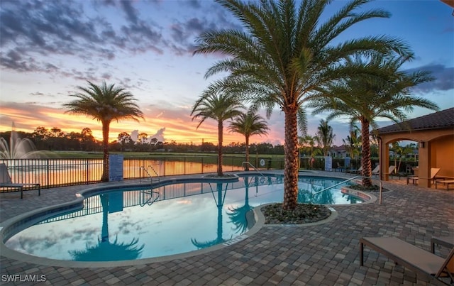 pool at dusk featuring a patio area