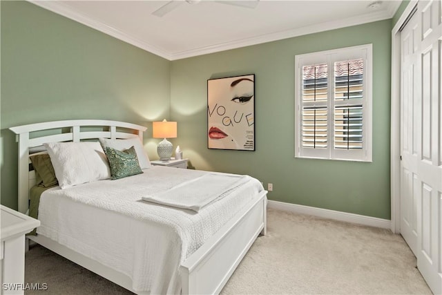 carpeted bedroom featuring ceiling fan, a closet, and crown molding