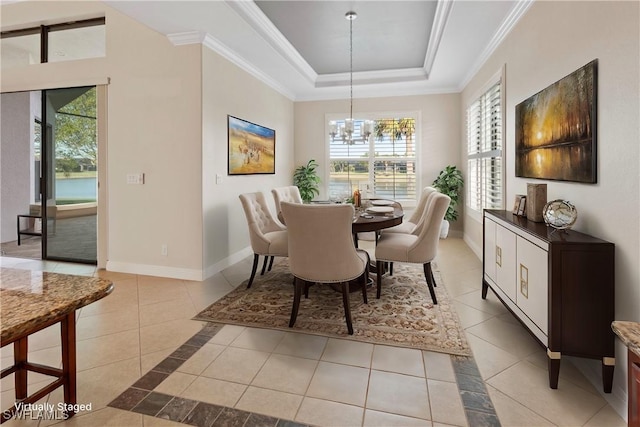 tiled dining space with ornamental molding, a raised ceiling, and a chandelier