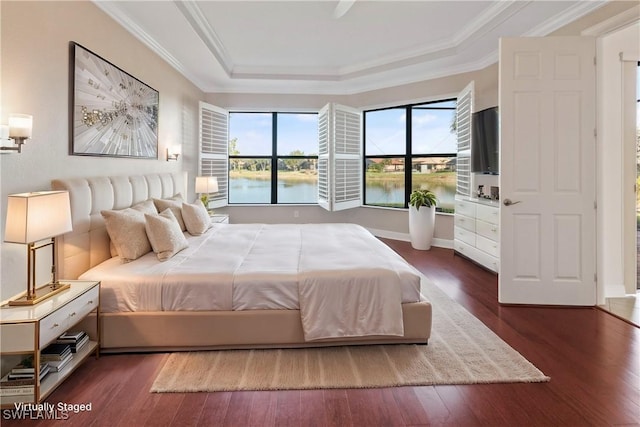 bedroom with dark wood-type flooring, crown molding, and a raised ceiling