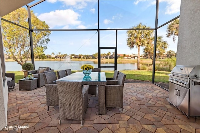 view of patio with a lanai, a grill, and a water view