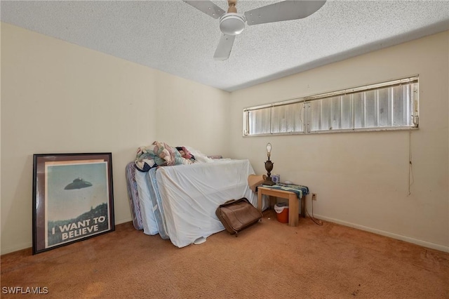 bedroom with ceiling fan, carpet, and a textured ceiling