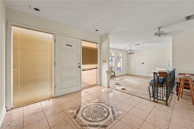 interior space with a textured ceiling and light tile patterned floors