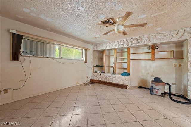 basement with ceiling fan and a textured ceiling