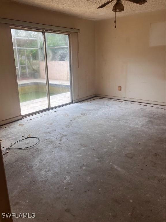 unfurnished room featuring ceiling fan, concrete floors, and a textured ceiling