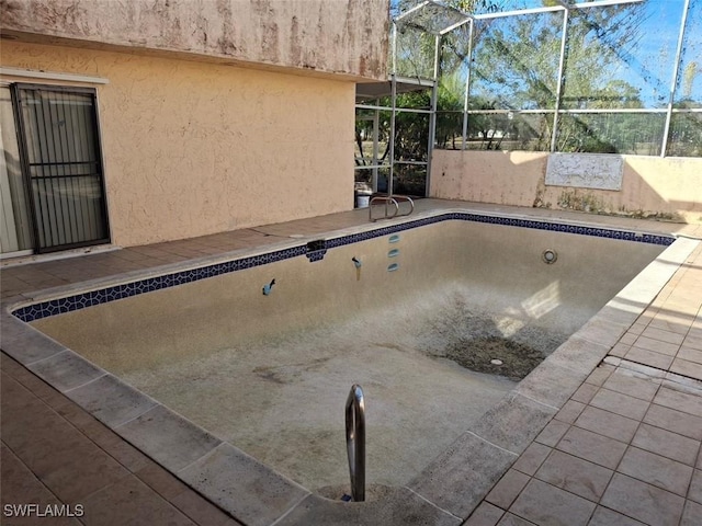 view of pool featuring glass enclosure