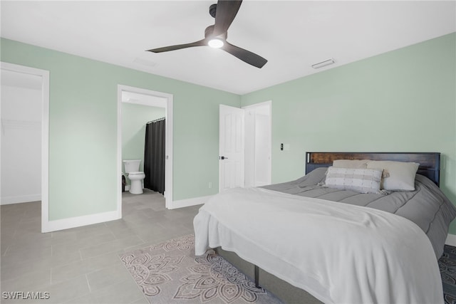 bedroom with a walk in closet, ceiling fan, light tile patterned floors, connected bathroom, and a closet