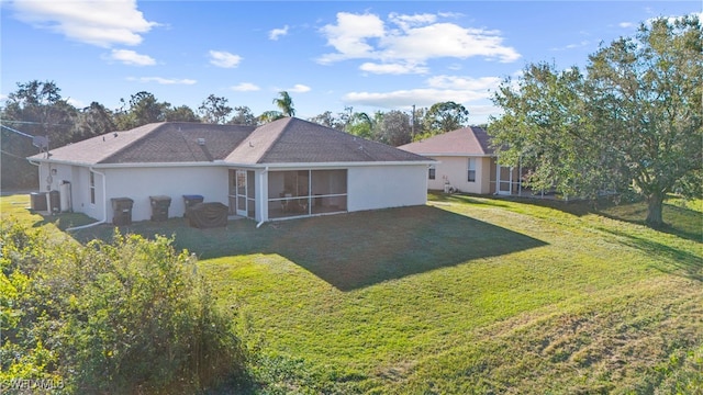 rear view of house featuring a lawn, a sunroom, and central air condition unit