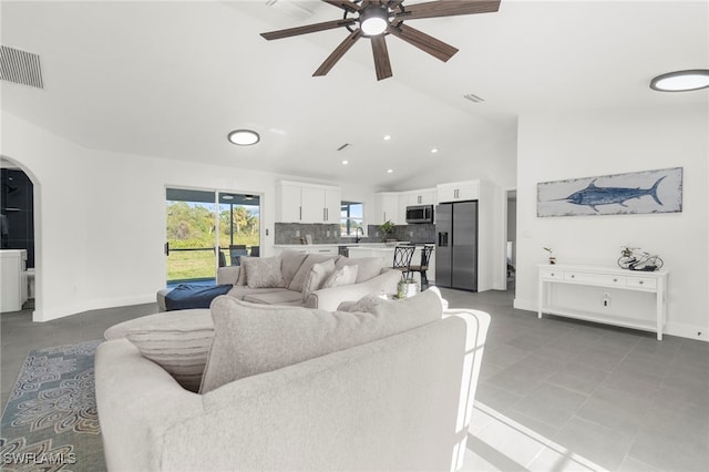 living room with ceiling fan, tile patterned flooring, and vaulted ceiling