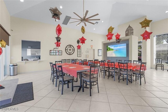 dining area with ceiling fan, light tile patterned flooring, and high vaulted ceiling