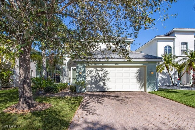 front of property with a garage and a front lawn