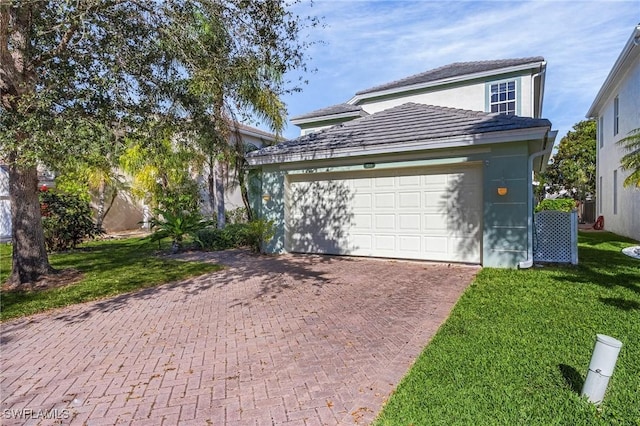 front facade featuring a garage and a front lawn