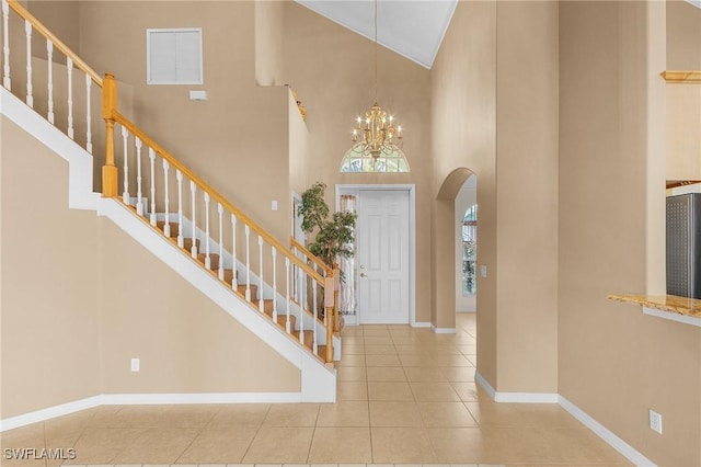 entrance foyer with a chandelier, a high ceiling, and tile patterned floors