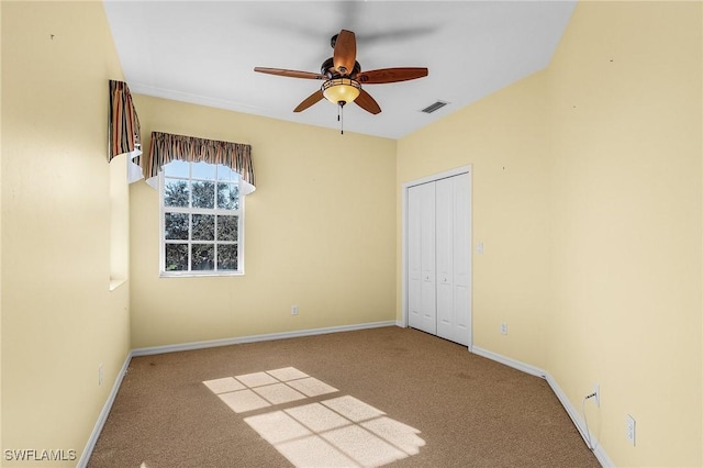 unfurnished bedroom featuring carpet, ceiling fan, and a closet