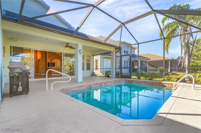 view of swimming pool featuring a patio, glass enclosure, and ceiling fan