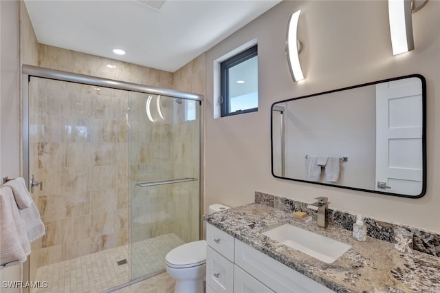 bathroom with vanity, toilet, and a shower with shower door