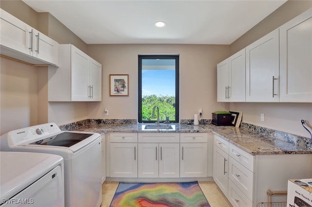 laundry room with washing machine and dryer, sink, and cabinets