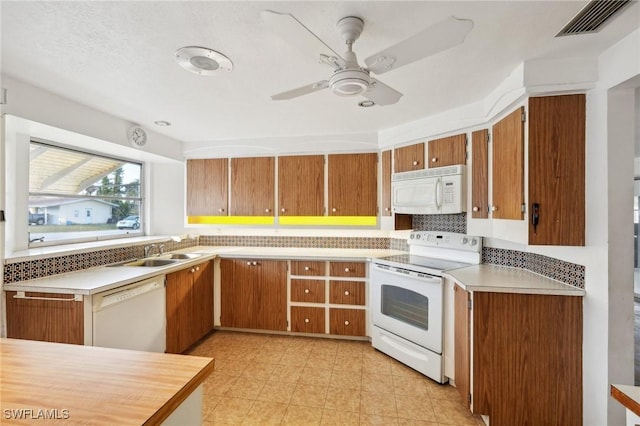 kitchen featuring decorative backsplash, ceiling fan, sink, and white appliances