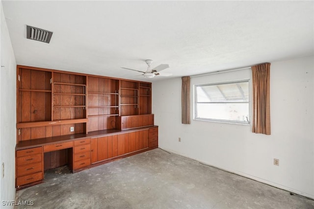 unfurnished office featuring ceiling fan and concrete floors