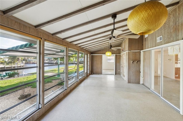 unfurnished sunroom featuring lofted ceiling with beams and a water view