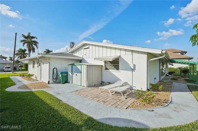 rear view of property featuring a yard and a patio